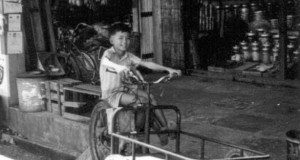 That is me as a kid sitting on my dad's three-wheel "Harley-Davidson" in Binatang